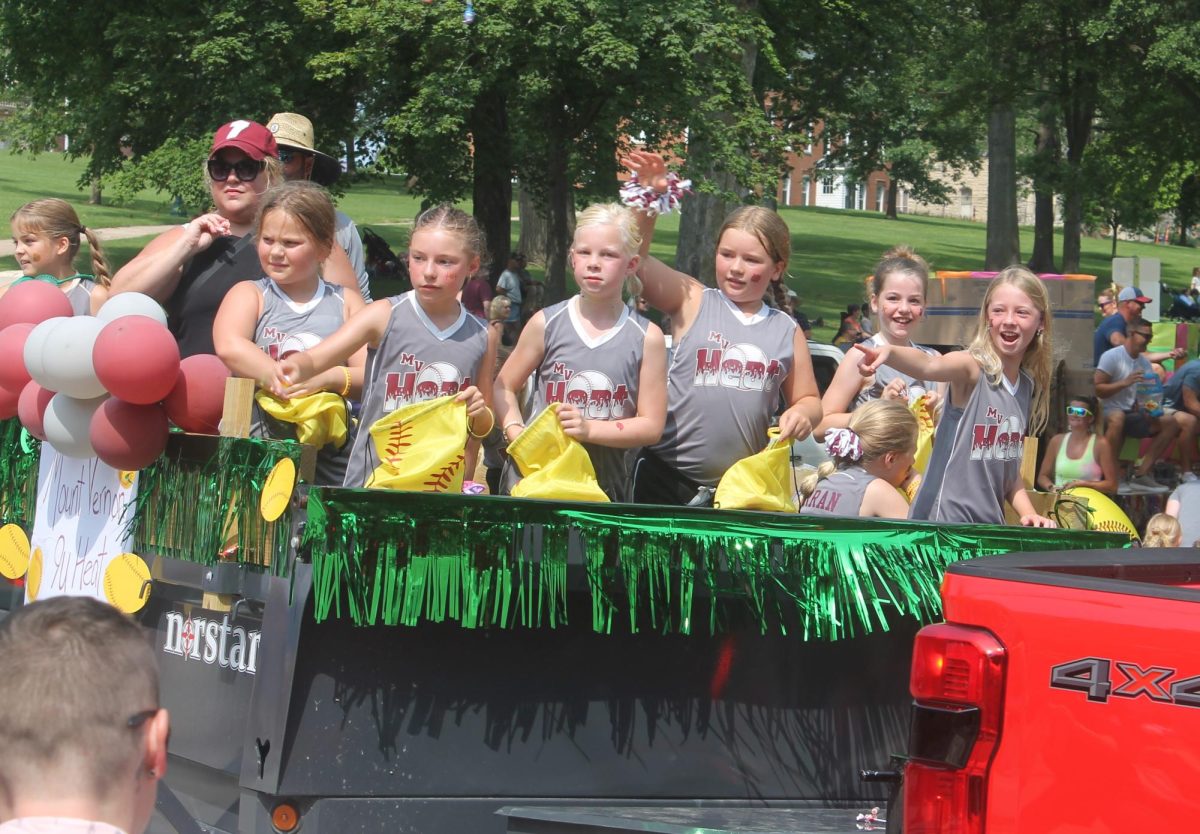 Members of the Mount Vernon Heat 9U softball team throw candy to people along the street Saturday, July 13. 