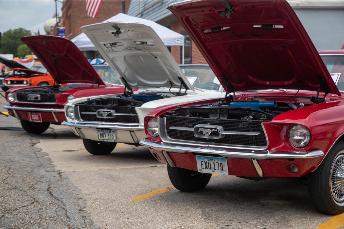 Three vintage Mustangs sit next to each other at the car show. They are all the 1967 version of the iconic car.