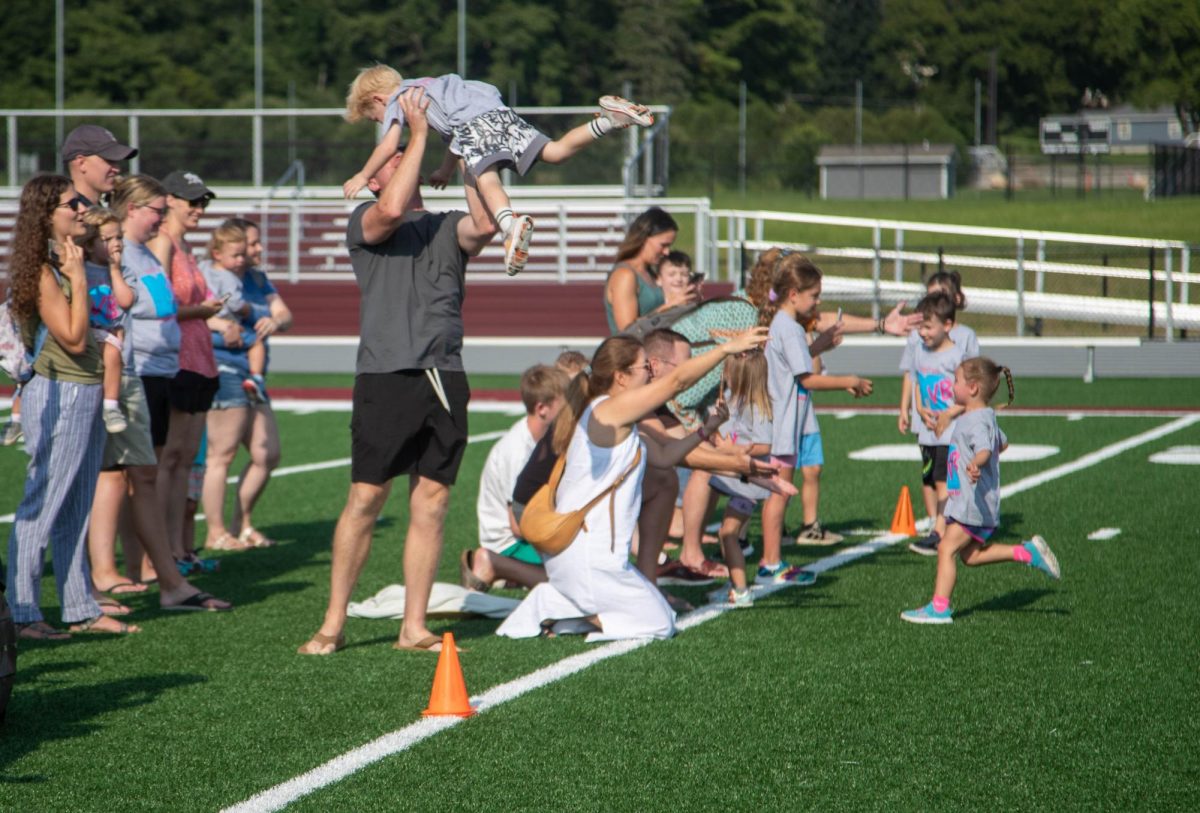 Jason Williams lifts his son, Tanner Williams, in joy after Tanner finished the fun run race. 