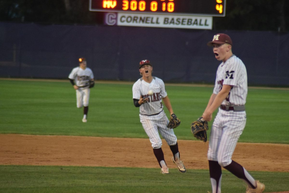 Mount Vernon shortstop Garet Swartzendruber tosses the ball while celebrating the final out with relief pitcher Caelb Foreman on Friday, July 12, at Ash Park. The Mustangs beat West Delaware, 4-2, in a Class 3A substate quarterfinal.