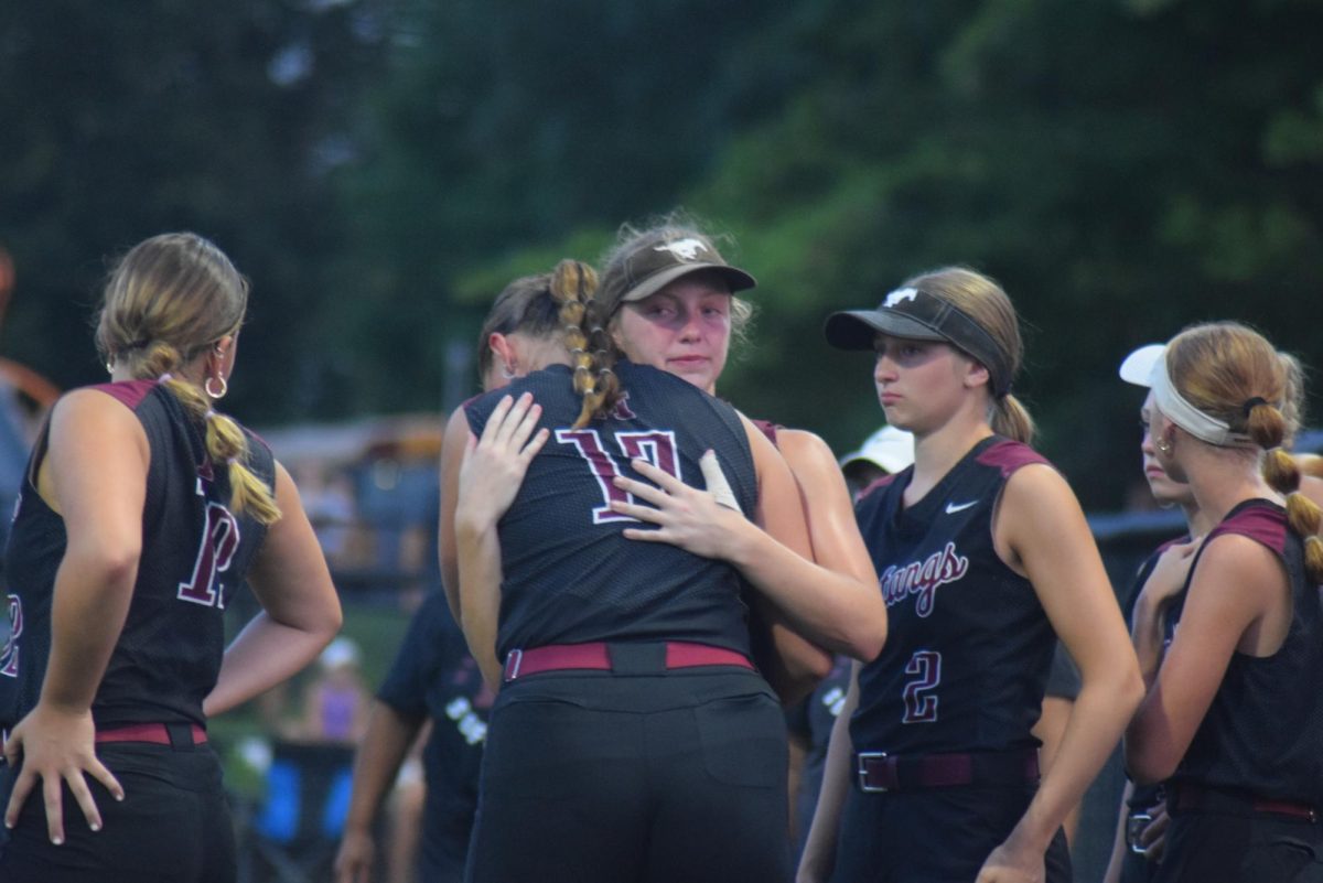 Mount Vernon pitcher Hayden Gookin gets a postgame hug from her senior sister Addison Gookin after the Mustangs failed to advance following a 3-0 regional semifinal loss to Center Point-Urbana on Saturday, July 13, in Mount Vernon.