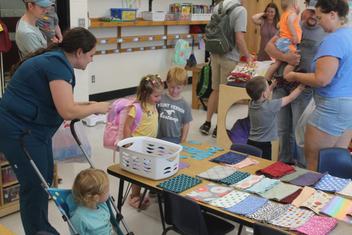 Lia finds her nametag to put with her chosen napkin and placemat in Ms. Hoppenworth’s preschool classroom. 