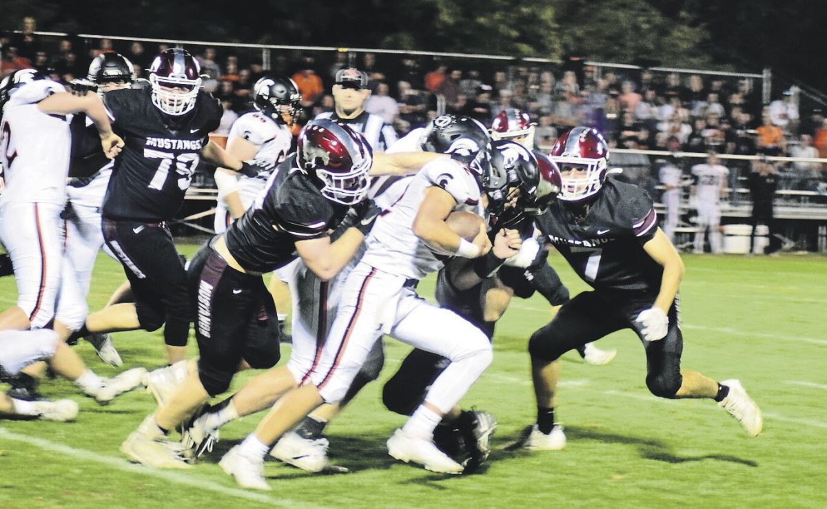 Mount Vernon’s Kellen Haverback (No. 8) holds on to a scrambling defender in play last season, as teammates Ethan Plotz (No. 5) and Jackson Jaspers (No. 21) come to assist.