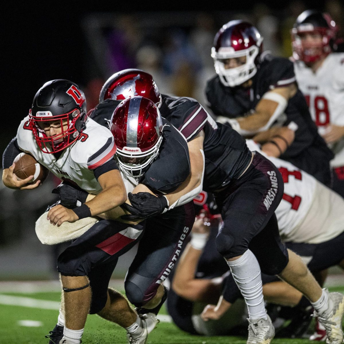 Union fullback Wyatt Walker gets tackled by a group of Mount Vernon Mustangs players during a high school football game between Mount Vernon and Union Community in Mount Vernon Friday, Sept. 6, 2024. The Mustangs defeated the Knights 43-6.