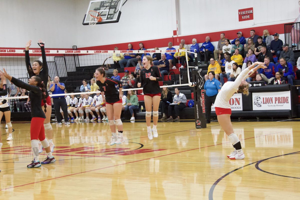 The Lions team including Mykala Luzum-Selmon, Sarah Dietsch, Kaitlynn Hasselbusch, Keira Bergmann and Presley Studt celebrate a point in the regional matchup.