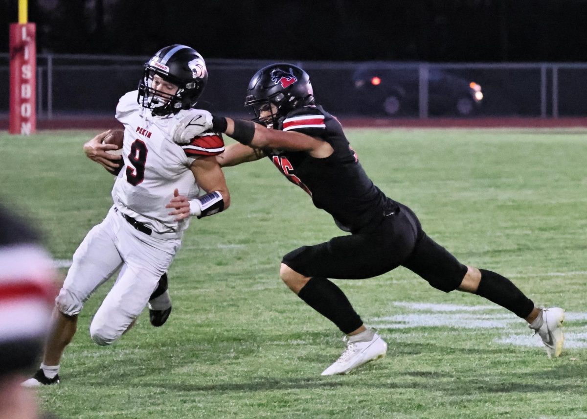 Lisbon’s Chase McFarlane (No. 16) works at tackling a Pekin player.