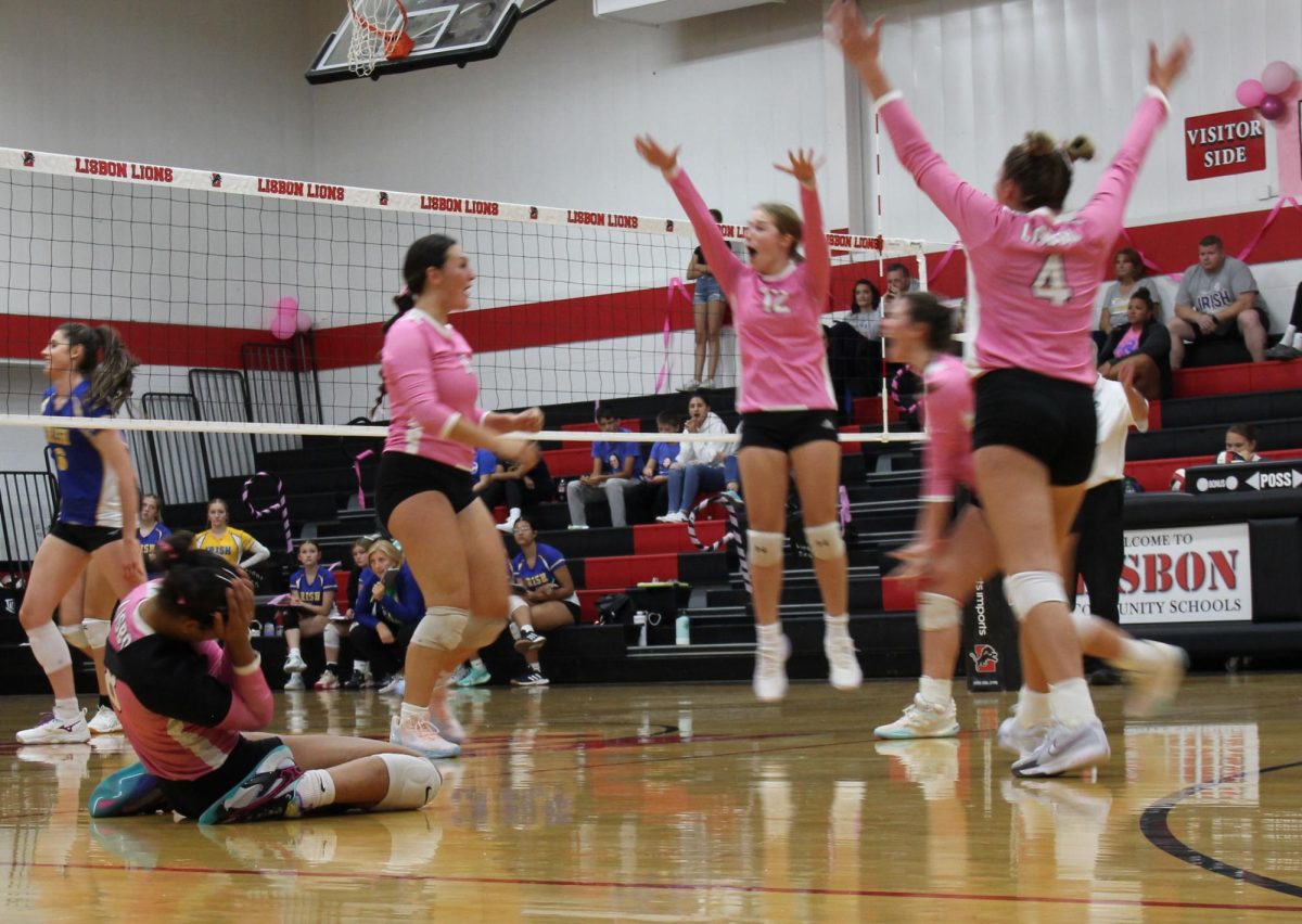 Lisbon players including Keira Bergman (No. 12) Mykayla Luzum Selmon (No. 8), Kamryn Kahl (No. 4) celebrate a point against Prince of Peace.