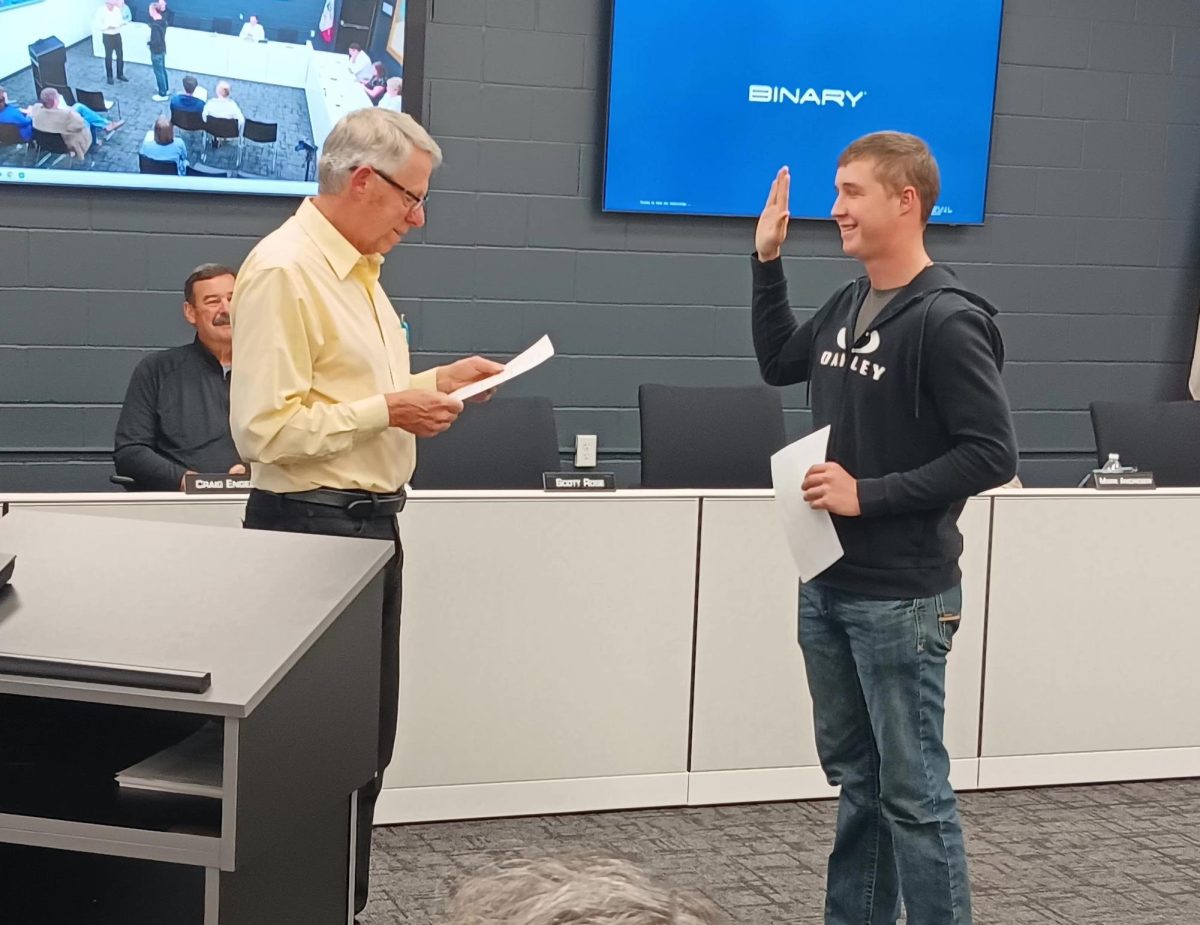 Mayor Tom Wieseler helps new Mount Vernon-Lisbon Police Department member Nick Eicher take his oath as officer.