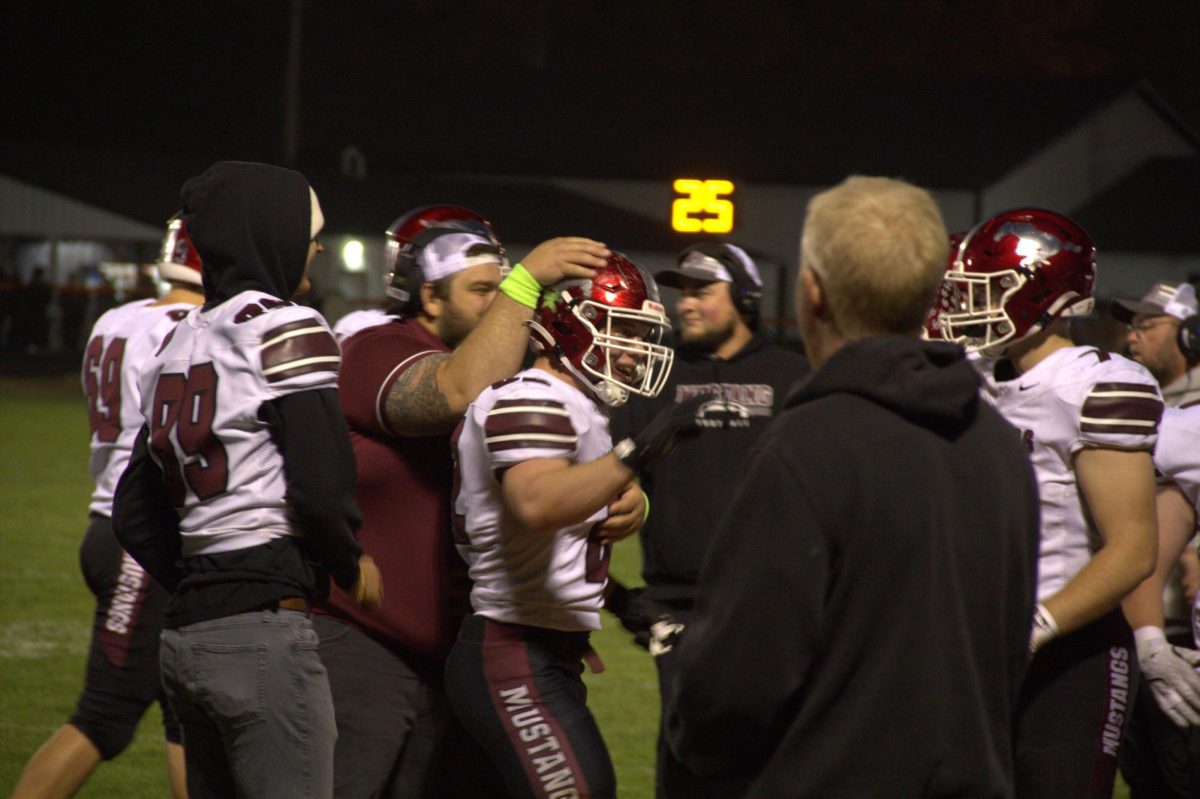 Coaches on the sideline congratulate Kael Riniker (No. 62) for his touchdown on a carry in rushing at Washington.