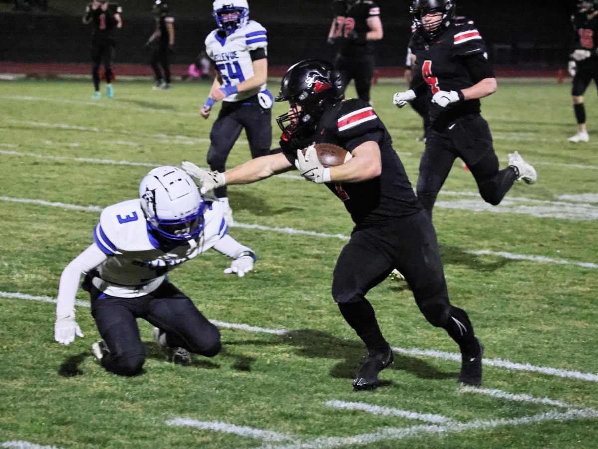 Lisbon’s Tiernan Boots (No. 7) gives a strong arm to a defender as he pushes for more yards down the field.