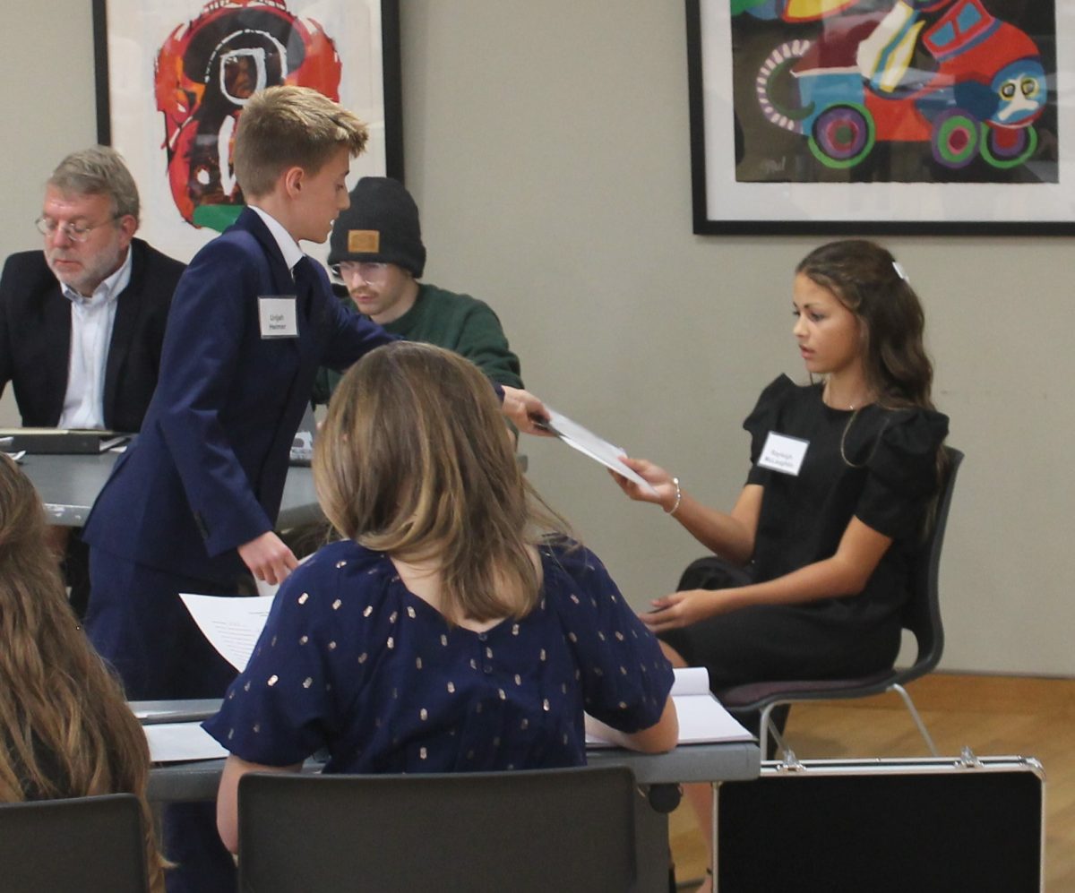 Urijah Helmer presents Ryleigh McLaughlin an exhibit during the mock trial. McLaughlin was a witness for the prosecution in the trial.