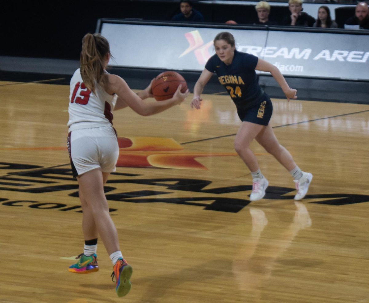 Kyla Kahl (13) catches a pass as she runs down the court at the X-treme Arena in Coralville, Iowa on Monday, Dec. 9th, 2024. Her opponent, Addie McLaughlin, scored 18 points for Regina Catholic.