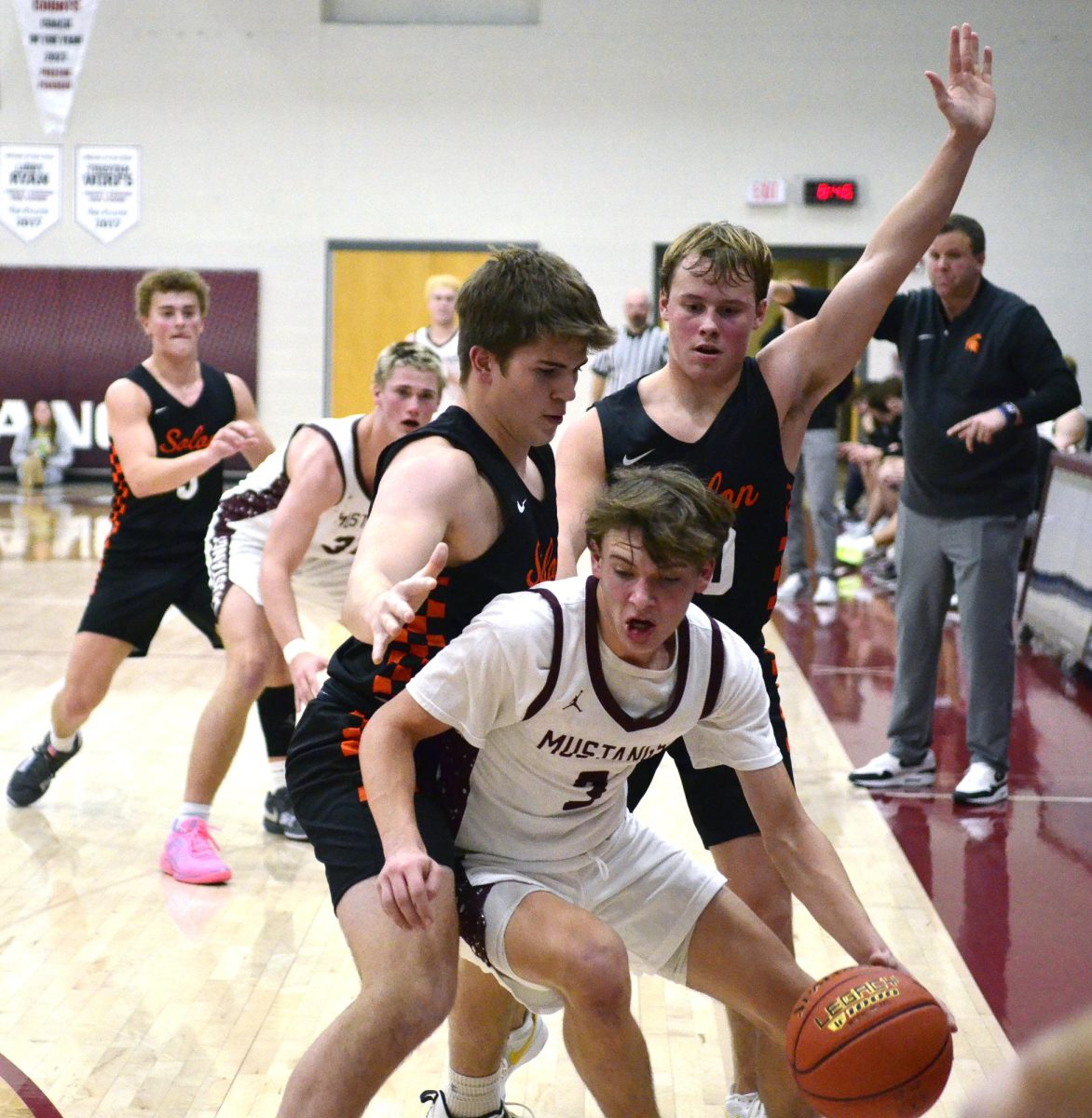 Solon’s Eddie Johnson (33) and Nolan Seagren (10) try to trap Luke Rushford (3) in the corner Tuesday, Dec. 17. The Mustangs improved to 5-0 with a 54-40 win over the Spartans.