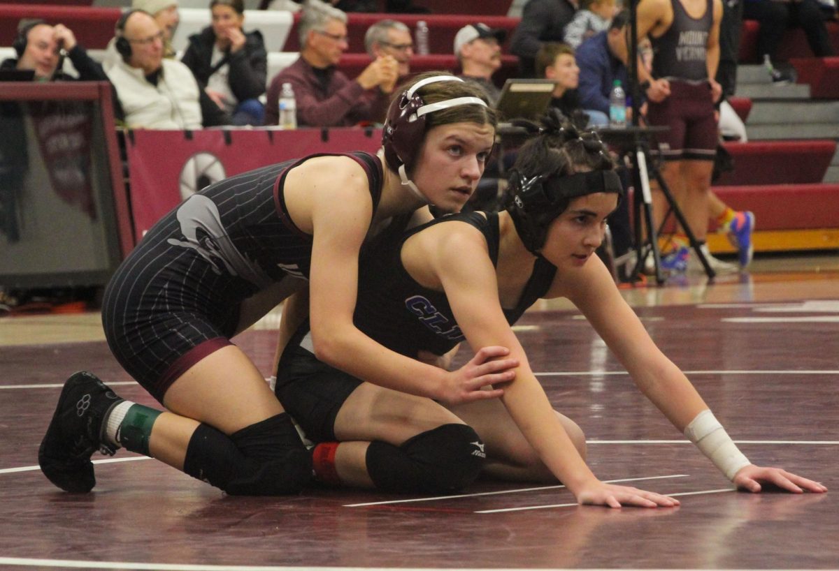 Mount Vernon’s Carly Elliott grapples with a Clear Creek-Amana wrestler earlier in the season.