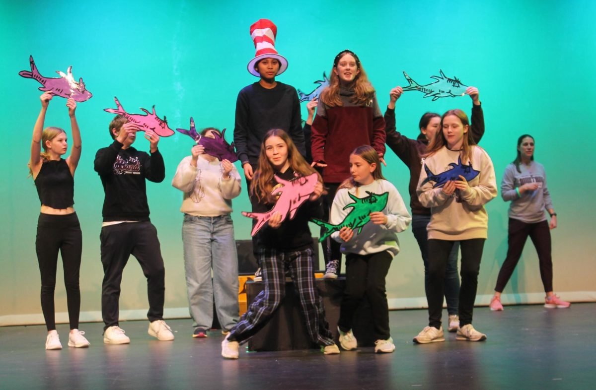 JoJo (Ronnie Yeater) and Cat In the Hat (Claire Anne Elloren) in the center of a choreographed number with fish in the Seussical, Jr. production.