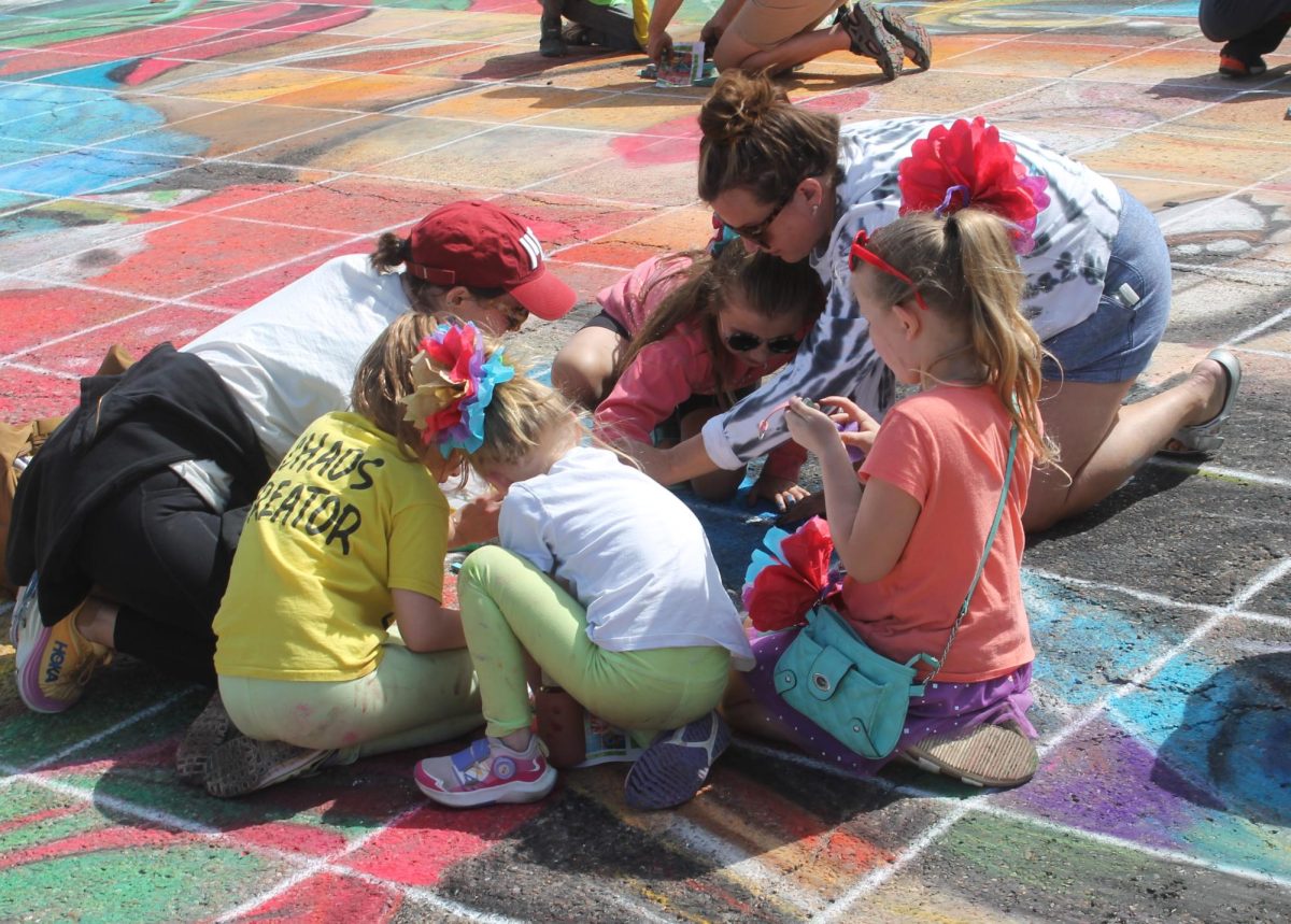 Participants finish up the community art piece at Chalk the Walk in May.