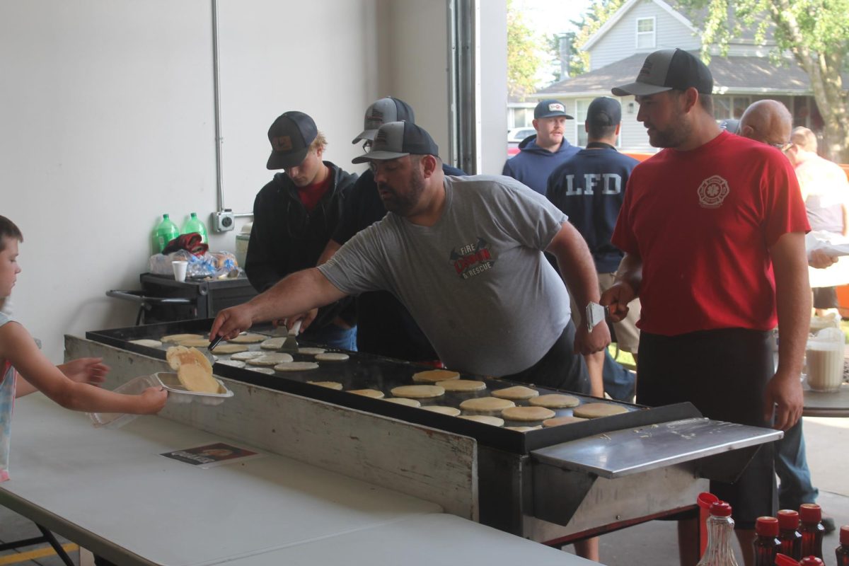 Ben Kelley, Chris Caspers and Jonah Light serve pancakes at the griddle Monday, Sept. 1.