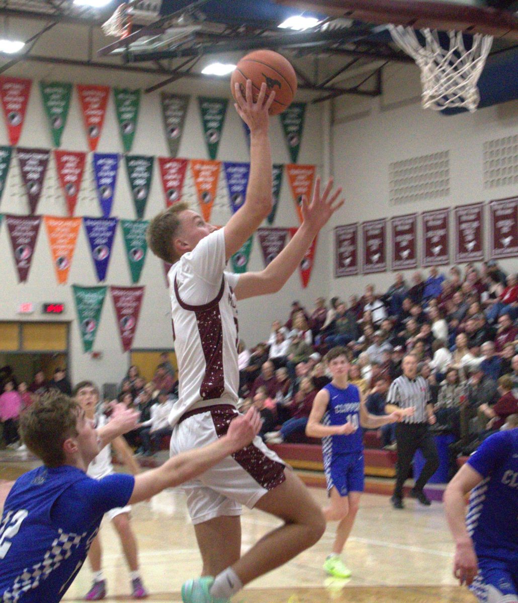 After getting past Clear Creek Amana defenders, junior guard Seth Rushford (33) leaps for the layup. Rushford finished second in scoring for Mount Vernon with 15 points on the night.