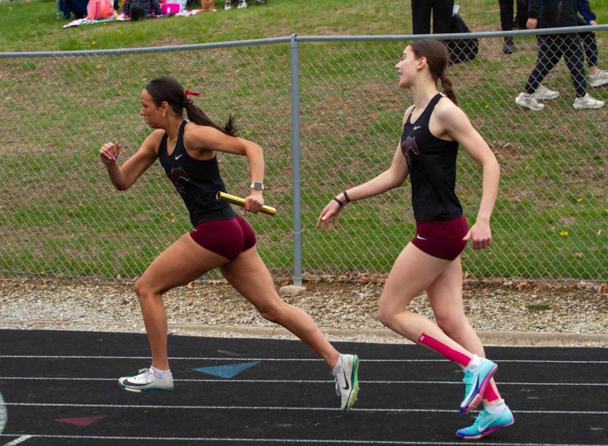 CaliAna Whitaker (left) receives a handoff at the 2026 Eastern Iowa Track & Field Festival on Saturday, April 11th, 2026.