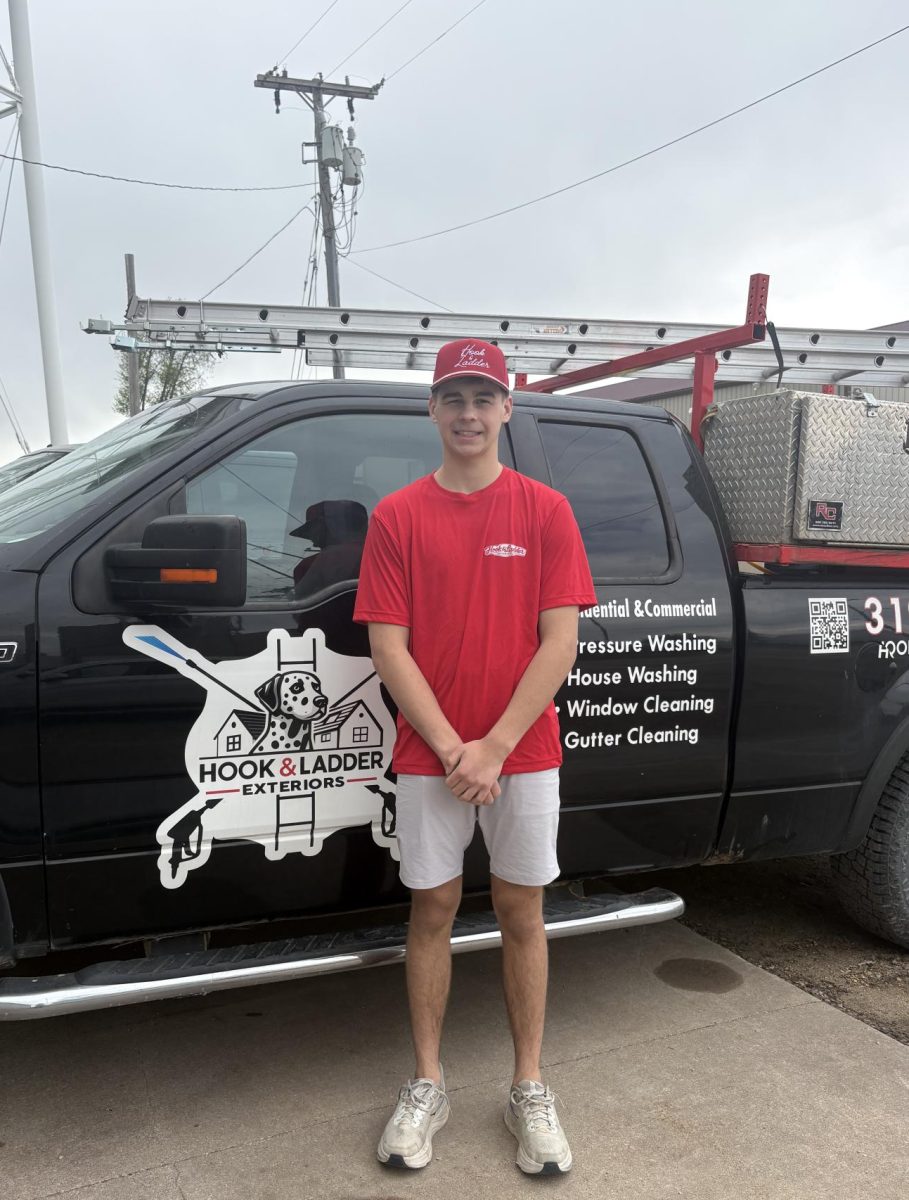 Caleb Keegan stands in front of his Hook and Ladder Exteriors truck in Mount Vernon. Keegan, a high school senior, runs the exterior cleaning business while also serving as a fire cadet.