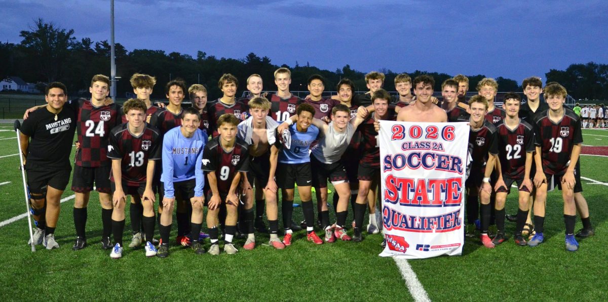 Senior Jaxon Anderson holds the State Qualifier banner as the Mount Vernon Mustangs pose for a team photo after their 1-0 win over rival Solon Friday, May 29, in a Class 2A Substate Final match. The win advanced the No. 5-ranked Mustangs to the State Tournament and a Quarterfinals match against No. 4 Bishop Heelan Monday, June 1 in Gilbert.